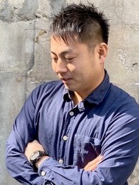 腕を組むブルーのシャツの男性の写真