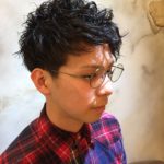 メガネをかけたショートパーマの男性の写真
