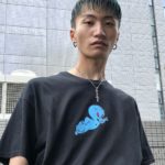 大きなピアスをつけた緑の髪の男性の写真