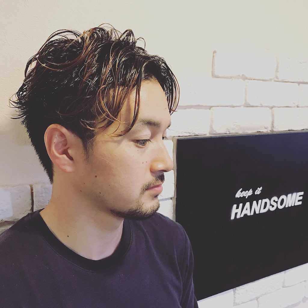 お店の外の壁に立つ男性の写真