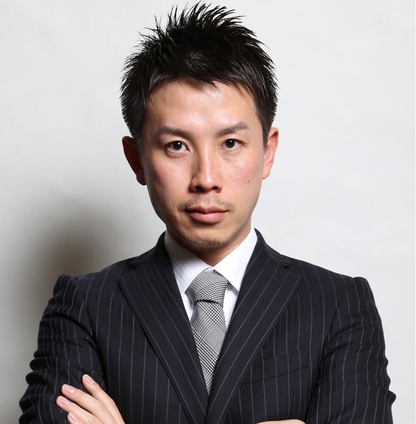 腕組みをするスーツの男性の写真