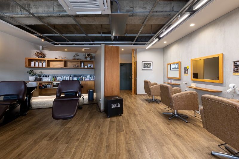 hair create FLYのウッド調のフロアとコンクリートの壁がマッチしたおしゃれな店内